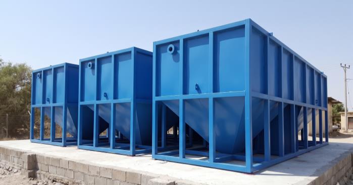 Blue steel wastewater treatment tanks on a concrete base